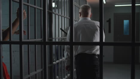 elderly prisoner in orange uniform sits in prison cell eats food          (stock footage)