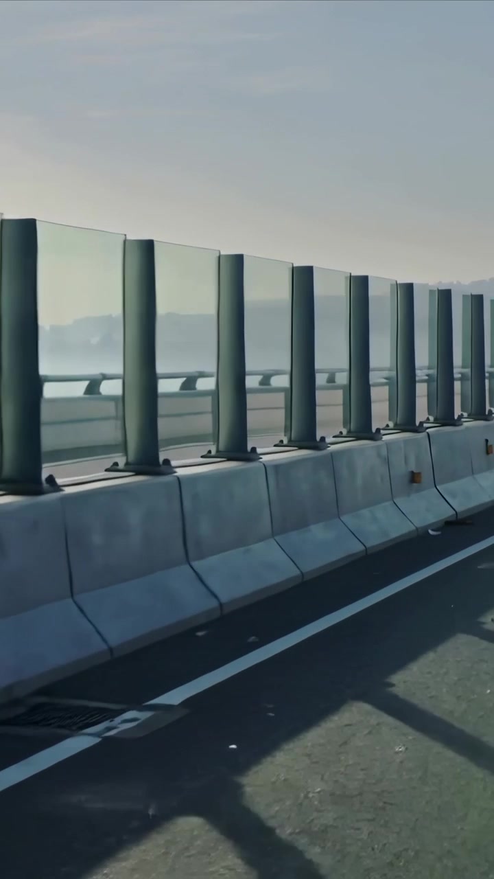 Vídeo vertical: Câmera avançando na ponte no início, revelando barreiras de pista e painéis de vidro.