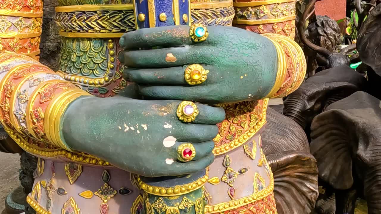 Close-up of a detailed guardian statue with vibrant armor and ornate facial features in an urban setting.