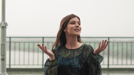 Woman-in-elegant-dress-looks-at-cloudy-sky-waiting-for-rain