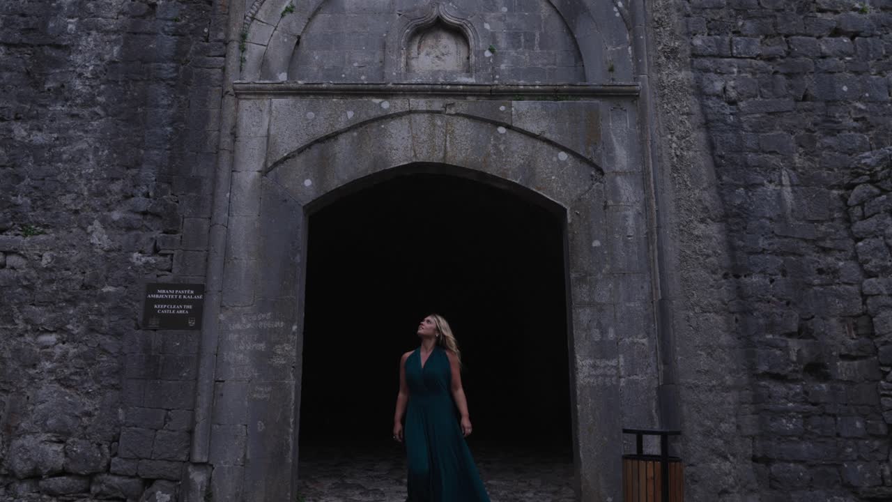 Blonde woman leaving the gate of Rozafa Castle, Albania. Slow motion
