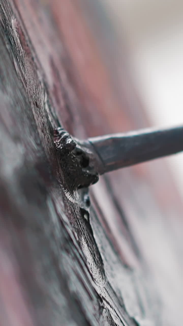 Dirty woman hand draws picture making rough smears with brush on canvas at art lesson in studio extreme close view slow motion vertical shot