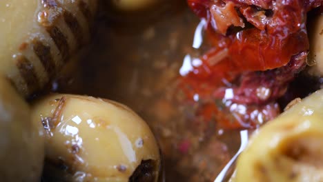 close up of green olives and sun dried tomatoes