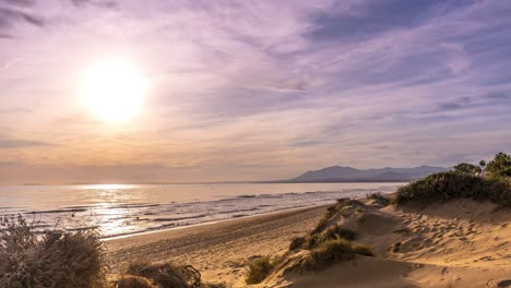 long time lapse of sun setting over marbella beach with people walking along the coast line with a beautiful sunset, spanish vacation in the coast del sol, malaga, spain