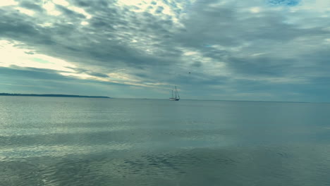 estacionamiento de barcos solitarios en el océano ancho durante el día nublado y ventoso, tiro ancho estático