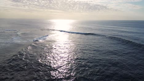 Drone-aerial-view-of-ocean-beach-sea-waves-early-morning-sunrise-reflection-travel-tourism-surfing-sky-NSW-Central-Coast-Wamberal-Australia-4K