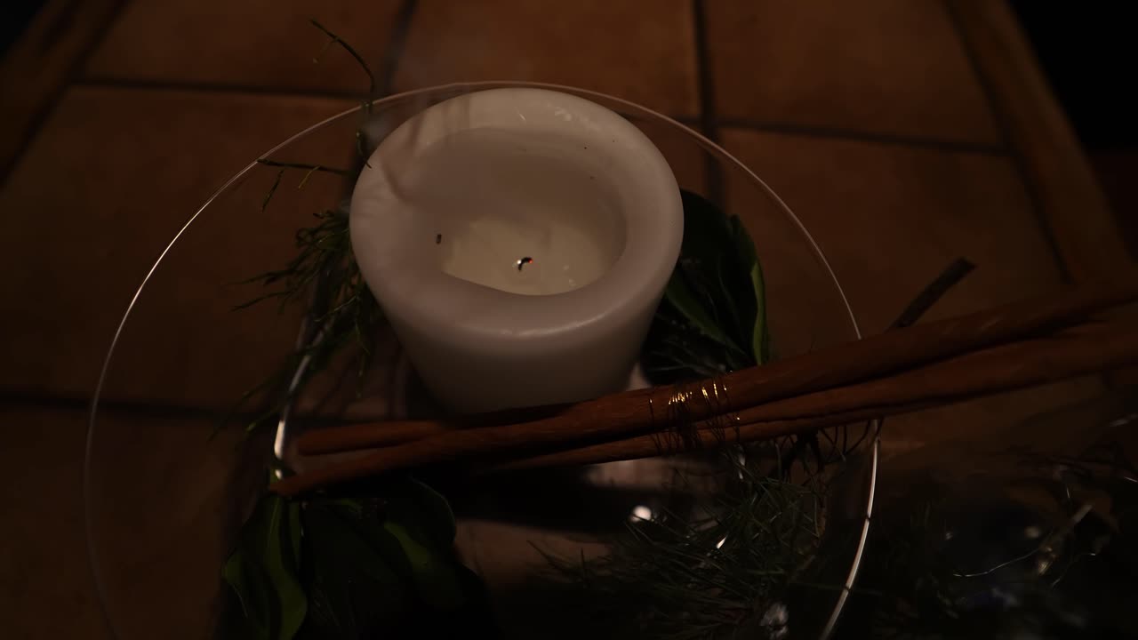 Gros plan vidéo montrant une flamme de bougie qui diminue et s’éteint, créant une ambiance intérieure calme et intime