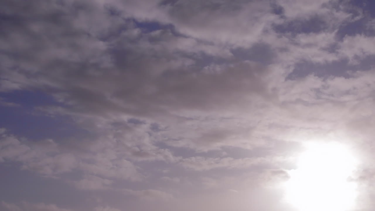 푸른 하늘에 극적인 구름과 함께 한낮에 태양의 저속