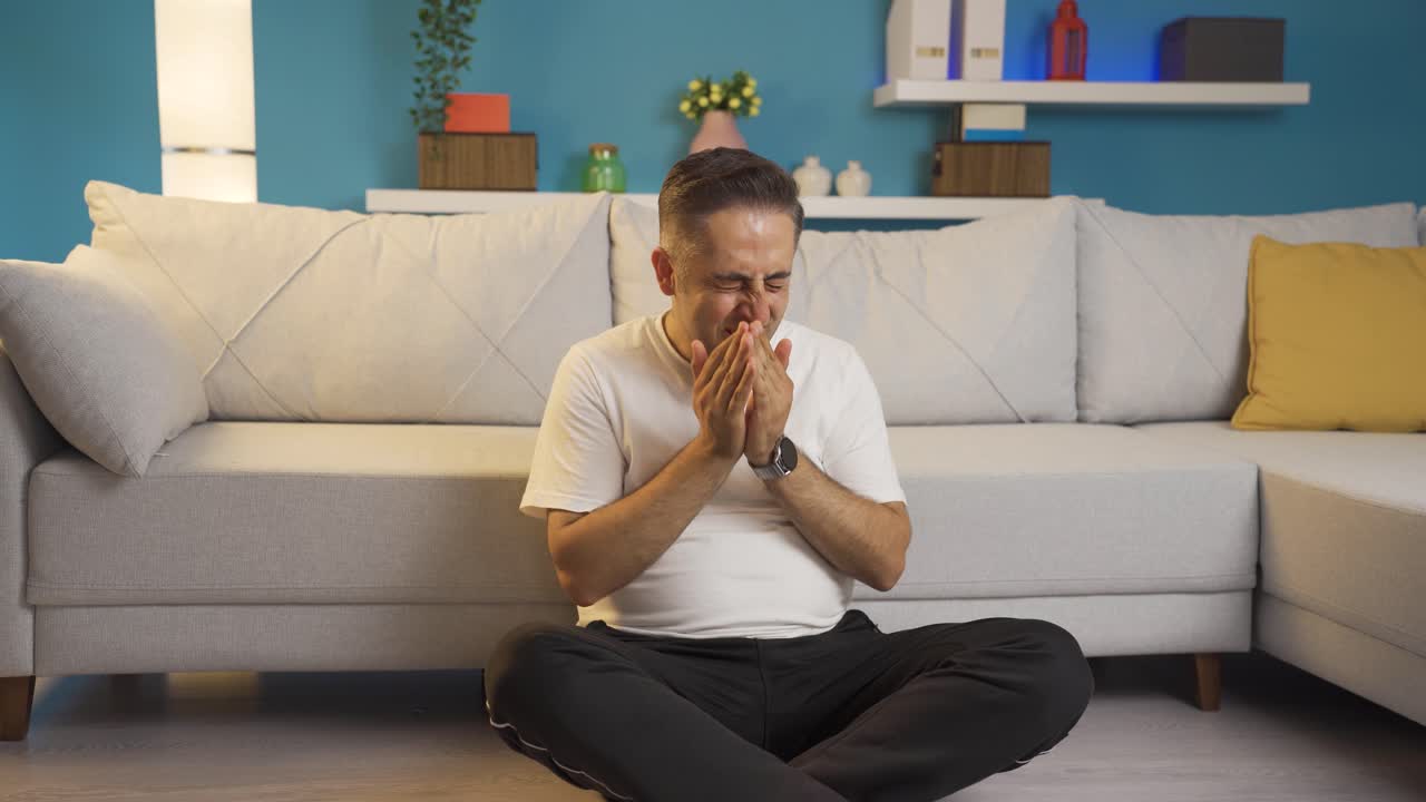 el hombre sentado en el suelo está llorando. desalentado.