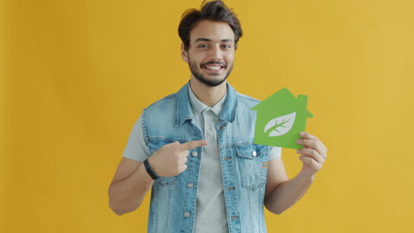 man holding eco-friendly house sign