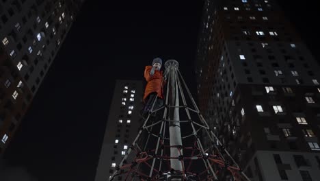 child climbing on playground at night