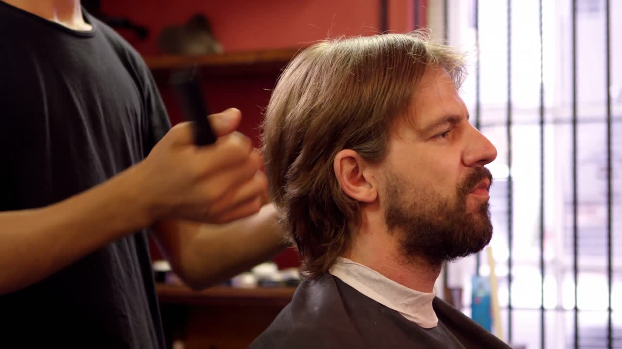 hombre cortándose el cabello por un peluquero 4k