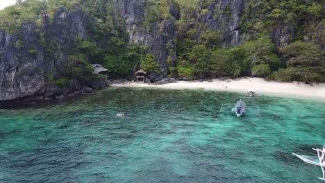 Filipino-island-hopping-Boats-Against-tropical-Serenity-Beach-of-Cadlao-Island-in-El-Nido,-Philippines