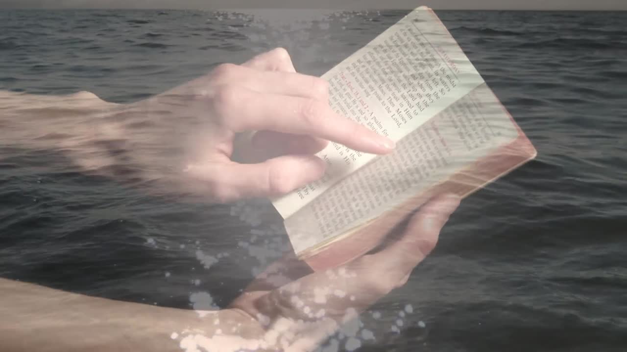 Animazione di mani di uomo caucasico che legge la Bibbia su paesaggio marino