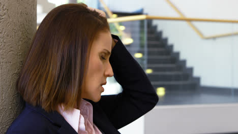 sad businesswoman sitting against wall 4k