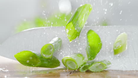 Cutting Chives With A Sharp Knife On A Wooden Water Covered Chopping Board in Macro and Slow Motion