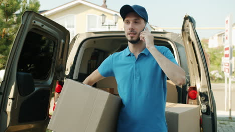 delivery driver talking on phone with boxes