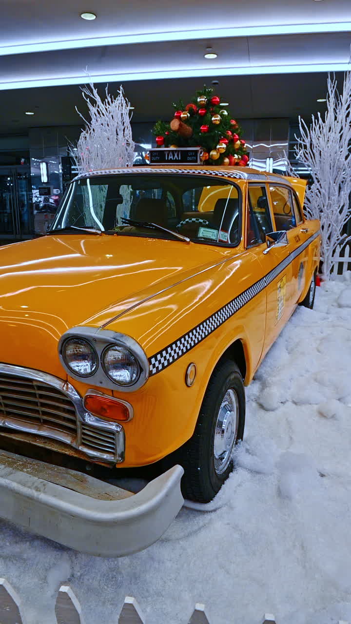 New York, USA, 20 December 2025: Yellow taxi in winter NYC. A vintage yellow taxi cab is decorated for the holiday season, set against a snowy backdrop in New York City