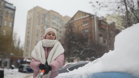 woman removing snow from a car in the city