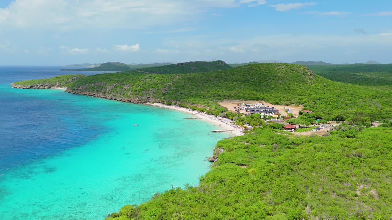 플라야 포르토 마리 위의 파노라마 공중 돌리 (panoramic aerial dolly) 는 구름이 아래의 물과 땅에 그림자를 던지면서