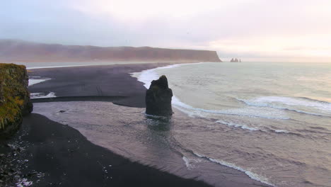 Panoramic-view-of-mountains,-ocean-and-birds-fluttering-around-on-an-overcast-day-in-Iceland