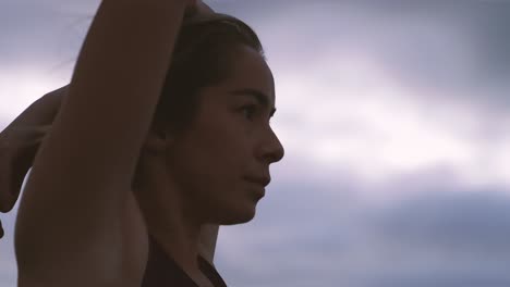 tight shot of woman stretching before workout at sunrise