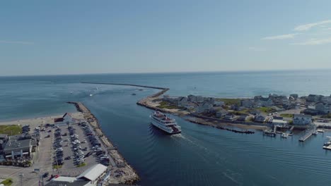 aerial of a block island ferry boat leaving a harbor in rhode island with passengers during the summer time