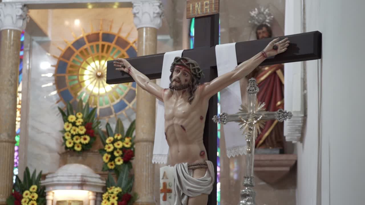 Primo piano di un crocifisso con statua di Gesù all'interno di una chiesa