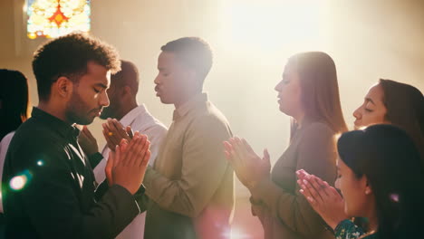 people praying together in a brightened place of worship during daytime