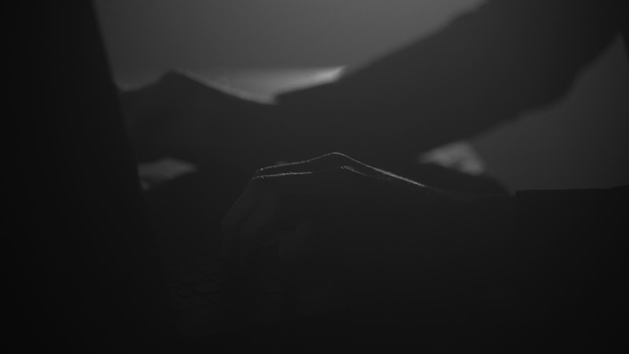 silueta de manos masculinas escribiendo en la computadora portátil