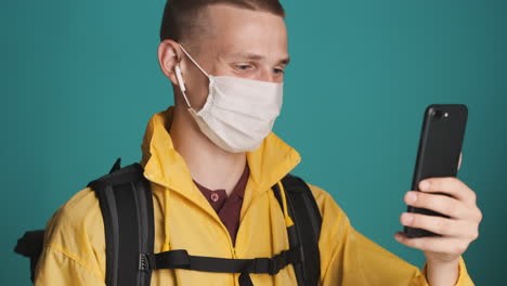 young man with face mask on a videocall