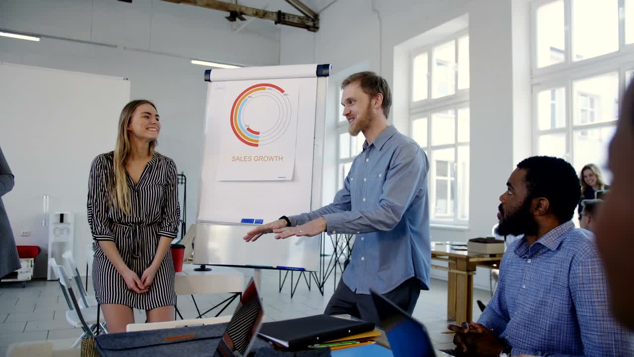 Multiethnic business people listen to young professional happy Caucasian coach leading office team training seminar.