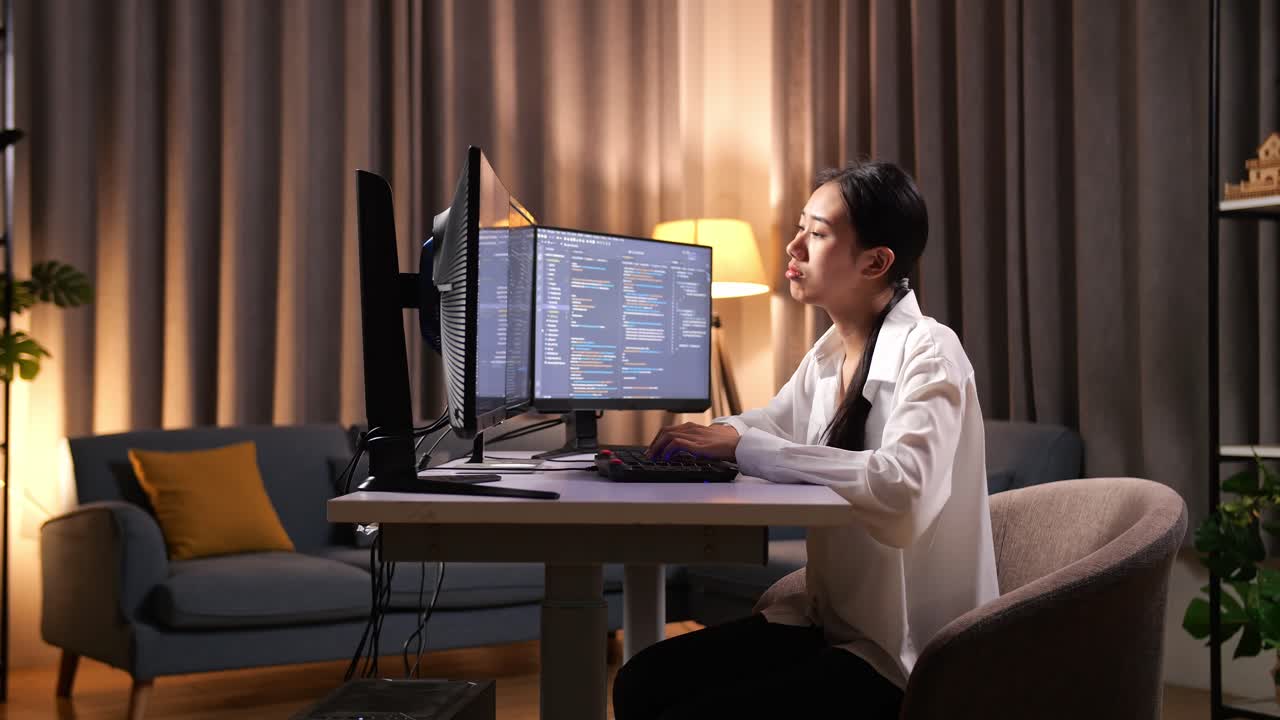 programadora asiática que se estira mientras crea ingeniero de software desarrollando aplicaciones, programas, videojuegos en computadora de escritorio en casa. terminal con lenguaje de codificación