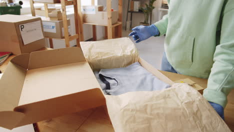 woman packing and preparing online orders in a home office