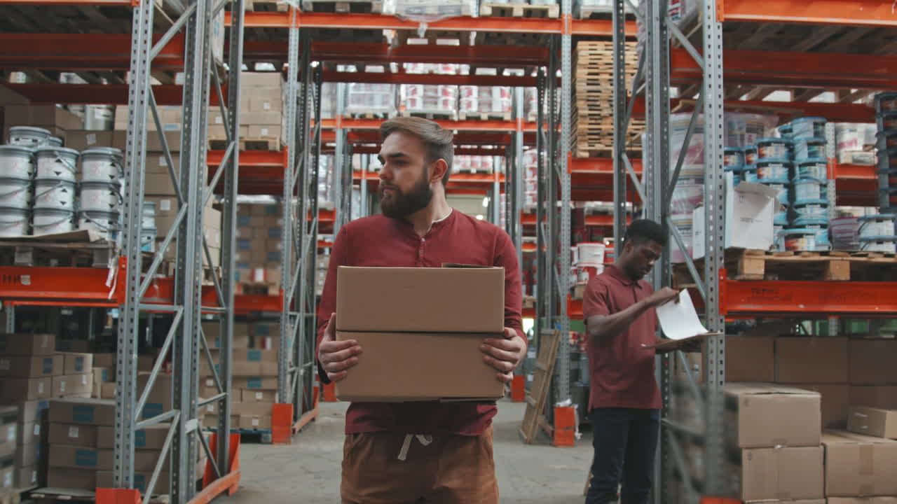 Worker Carrying Boxes and Walking in Warehouse