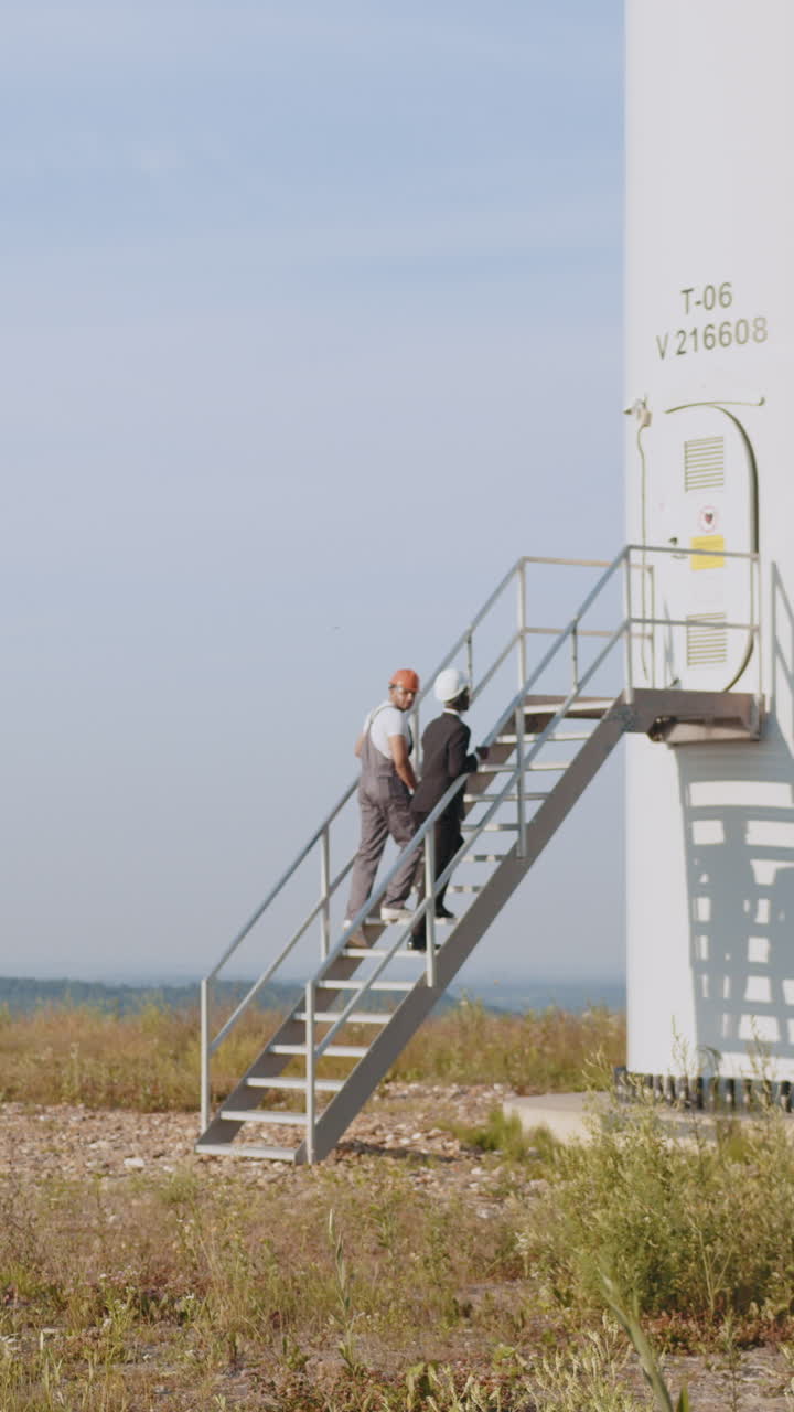 Engineers ascending wind turbine stairs