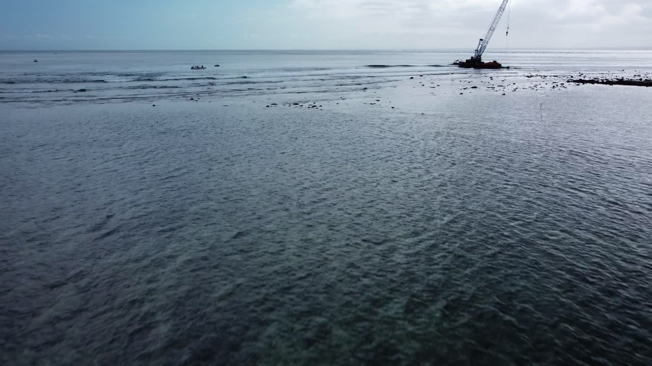 Aerial dolly shot of the famous shipwreck near nusa lembongan overlooking calm shallow waves in the sea during an adventurous and historic journey through bali, Indonesia