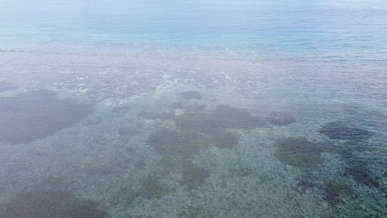 vuelo aéreo de drones sobre el océano con arrecifes de coral