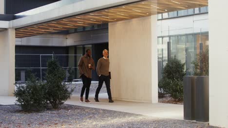 hombres de negocios caminando y hablando al aire libre