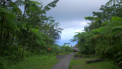 tourist at end of a path in the distance looking the landscape from a high viewpoint