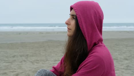 close up portrait of casual brunette young woman smiling with a hood