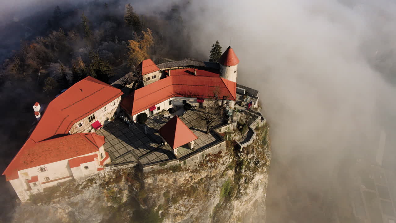 Vista aerea all'ora d'oro del Castello di Bled, circondato da nuvole mattutine