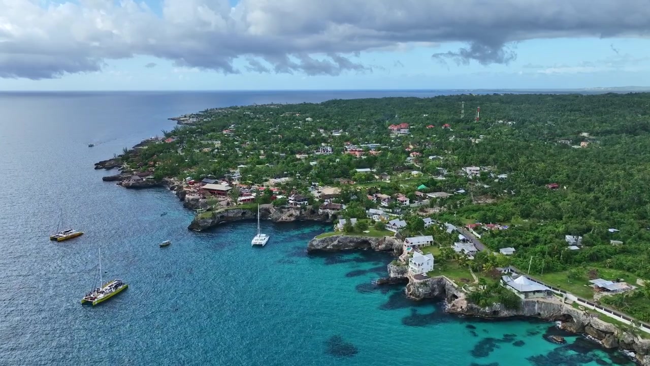 Ripresa con drone del mare con barche e terra a Negril West End.
