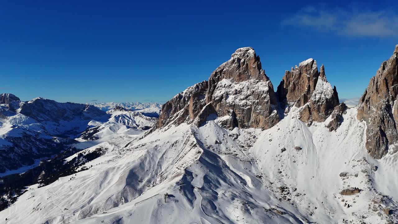 Big raw rock formation in the Italian Dolomites covered in snow during winter season (drone footage)