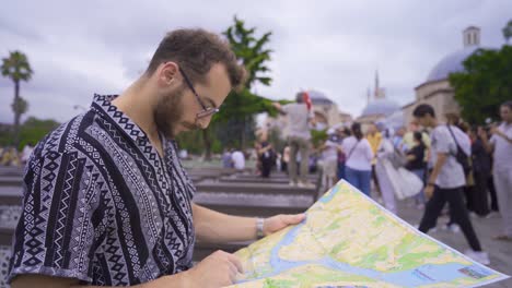 o homem em close-up mostra a rota num mapa de papel.