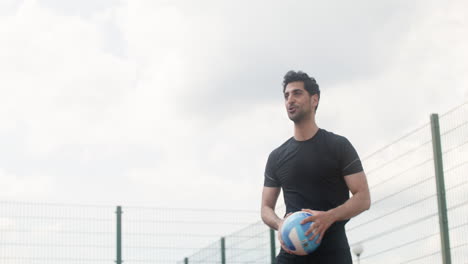 Lower-view-of-brunet-man-hitting-a-volleyball