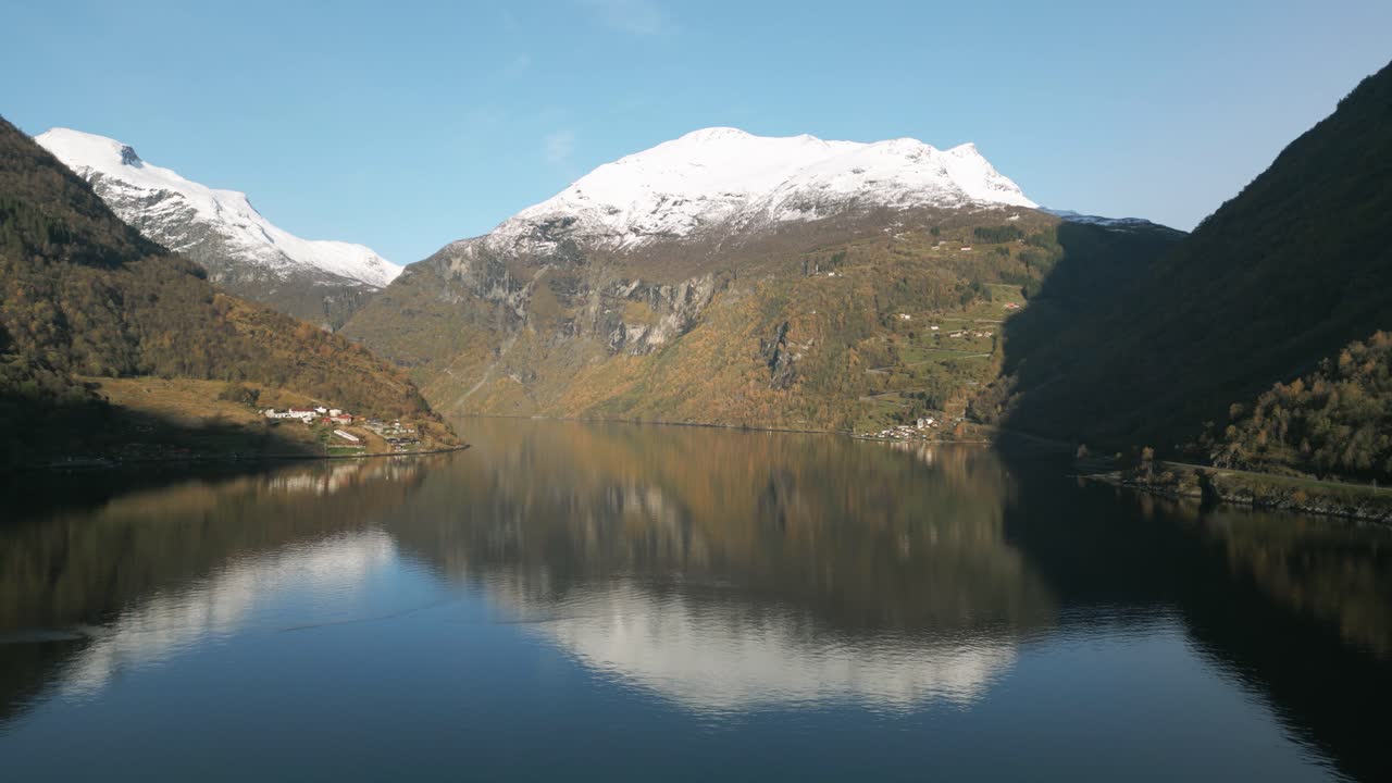 Calm Geirangerfjord waters with snowy mountains reflecting in Norway, serene nature scene