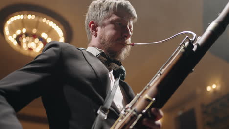 un musicien talentueux avec un instrument à vent traditionnel sur scène un homme joue du fagot soufflant de l'air