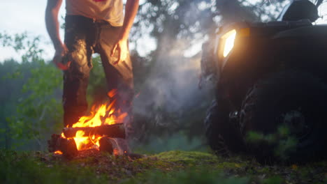 Placing-firewood-on-camping-fire-in-the-woods