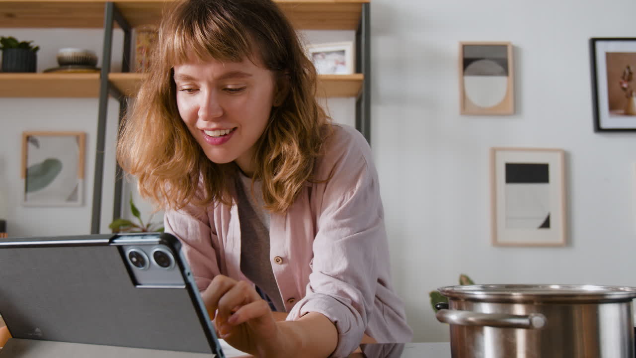 mujer usando tableta en la cocina